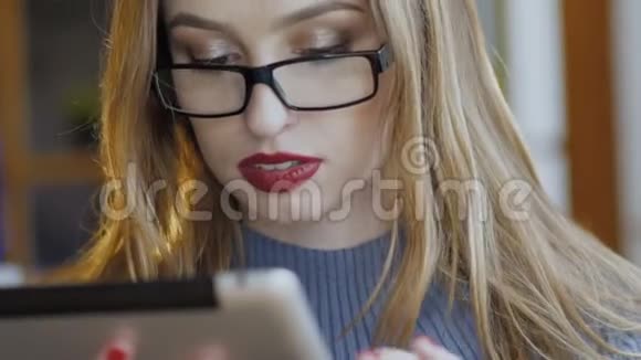 快乐的年轻女人在咖啡馆里和平板电脑一起工作慢慢地视频的预览图