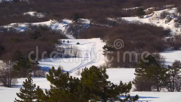 山谷里的人们骑着雪地摩托视频的预览图