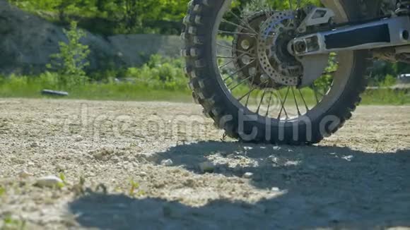 摩托车轮开始旋转和踢地面或污垢摩托车开始运动慢动作视频的预览图