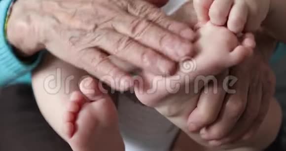 一位老妇人抱着新生儿柔软的腿视频的预览图