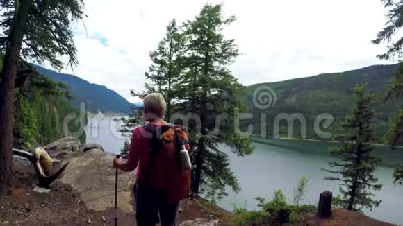 有登山杆的成熟女人站在河边4k视频的预览图