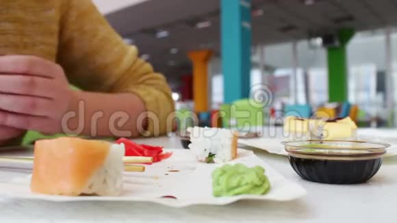 女孩坐着积极地做手势与桌上咖啡馆里的对话者交流他们是寿司日本菜视频的预览图
