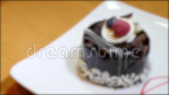 一个单份蛋糕躺在一个白色的盘子里镜头开始聚焦再次失去焦点视频的预览图