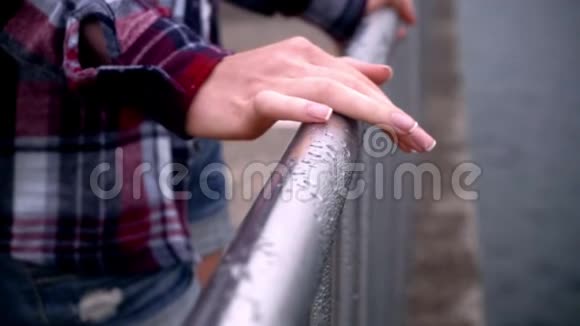 女人手在钢围栏上优雅的女士修剪过的手视频的预览图