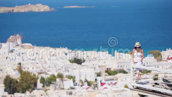 美丽的年轻女子在豪华酒店看书在希腊的Mykonos有着令人惊叹的景色视频的预览图