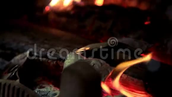 热红的煤躺在篝火里柴火燃烧着红色的火焰视频的预览图