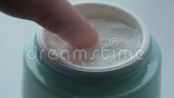 绿罐带着化妆品温和的奶油女性手指触摸奶油近距离观看奶油大指法视频的预览图
