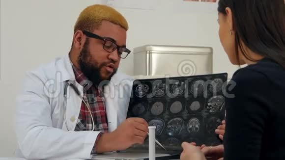 非裔美国男医生向女病人解释脑部X射线图像视频的预览图