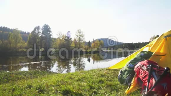 阿尔泰黄色帐篷在山湖畔花费红色背包和旅游靴两个视频合一视频的预览图