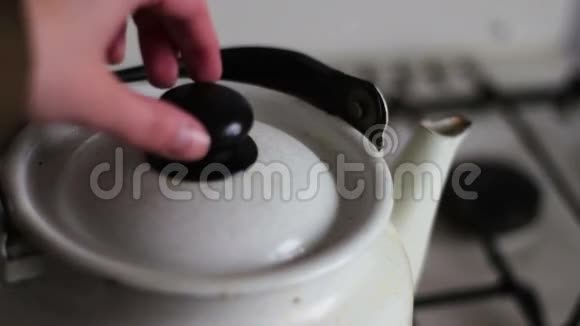 老式的白色茶壶站在炉子上煮东西视频的预览图