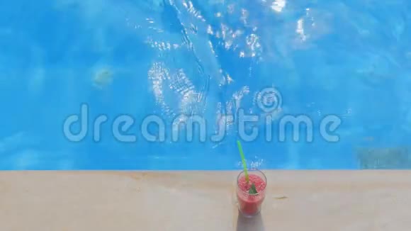 站在游泳池附近的一杯果汁视频的预览图