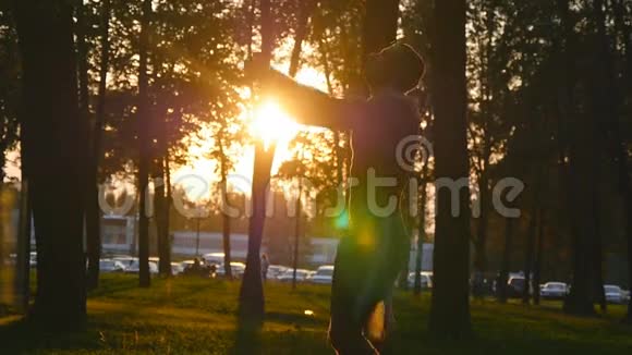 在城市公园训练前运动员跳跃和热身的剪影太阳在后台强壮有力的肌肉视频的预览图