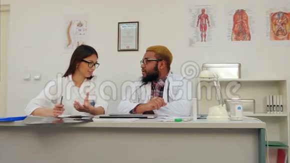 两位兴高采烈的医生在办公室里讨论视频的预览图