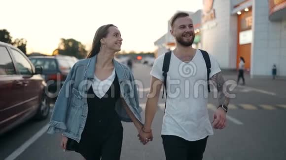 年轻漂亮的一对情侣一起走在大街上从100英尺的高空缓慢地微笑着视频的预览图