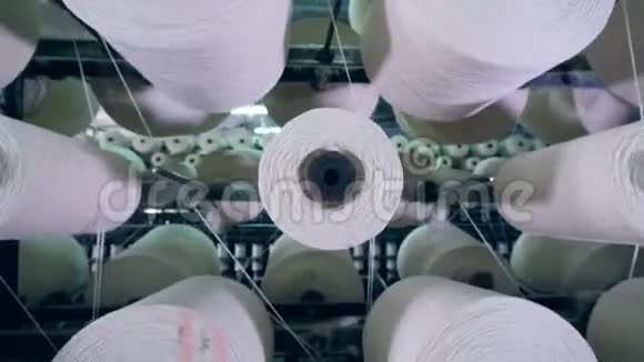 有白色螺纹的卷筒是旋转的纺织厂设备视频的预览图