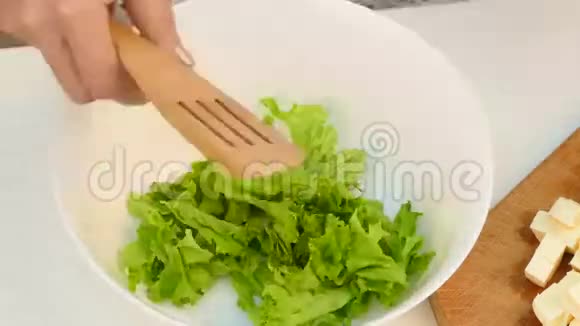 当一个女人在厨房准备一份新鲜的成熟蔬菜沙拉时时间就过去了视频的预览图