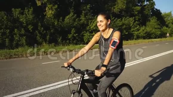 快乐的年轻女孩骑着自行车在城外健康的生活方式视频的预览图