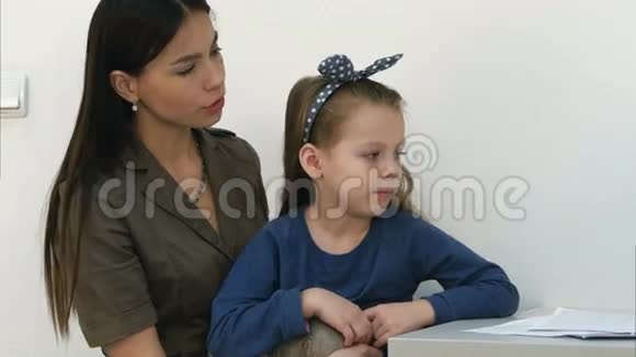 男儿科医生检查小女孩和她妈妈坐在一起的喉咙视频的预览图
