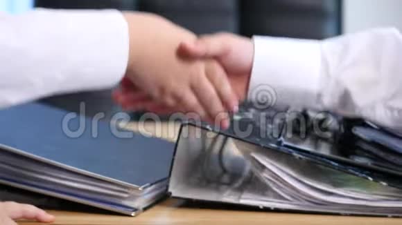 两个孩子在办公室背景上握手视频的预览图
