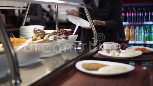 年轻女子把食物放在食物场的盘子里视频的预览图