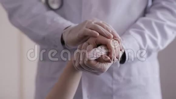 医生的双手抚摸着病人手安慰和抚慰她视频的预览图