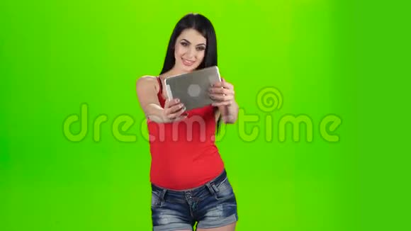 绿色屏幕使用平板电脑前摄像头拍摄的自拍照黑发女郎视频的预览图