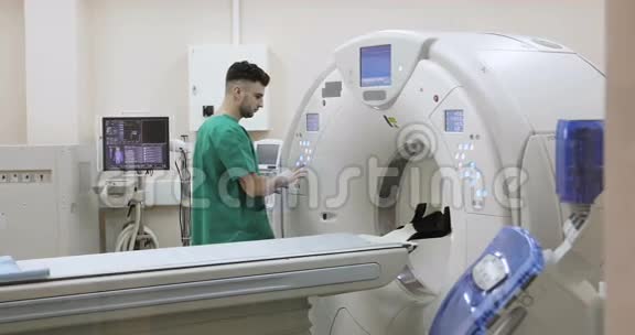 4两位医生按下CTMRI扫描仪的设置按钮视频的预览图
