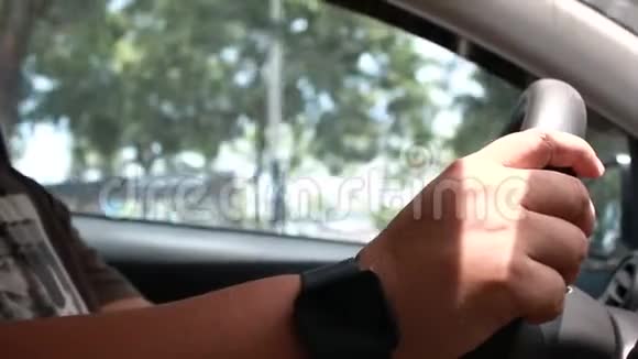 在城市里驾驶汽车的人的双手合拢在周围的声音中左转向视频的预览图