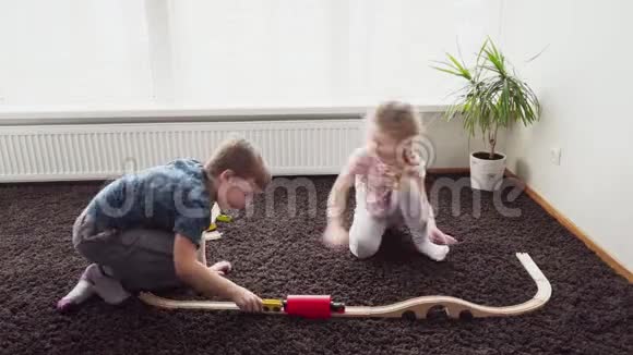孩子们在地板上的房间里搭玩具铁路视频的预览图