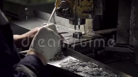 手在制造小型金属紧固件的机器上工作视频的预览图