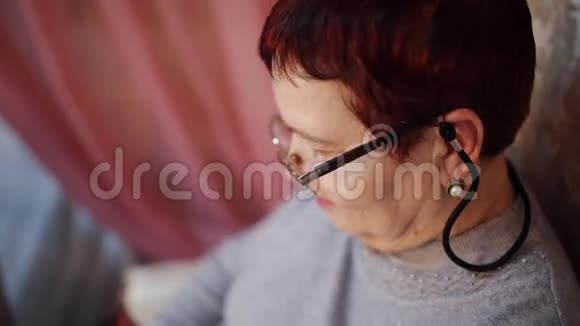 一位戴眼镜的老妇人坐在扶手椅上视频的预览图