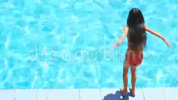 这个孩子正在游泳池的碧水里游泳从上面看女孩潜入水中视频的预览图