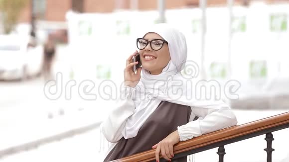 年轻的穆斯林女孩使用智能手机视频的预览图