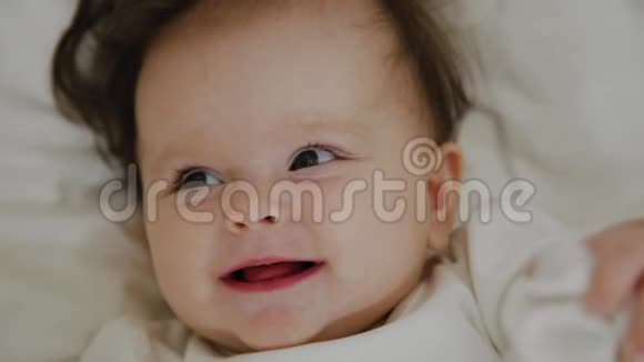 美丽的小女孩醒来对着镜头微笑视频的预览图