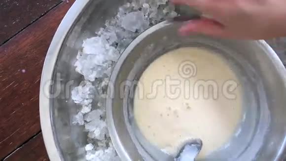 在钢碗中旋转牛奶奶油使其冻结并成为冰淇淋视频的预览图