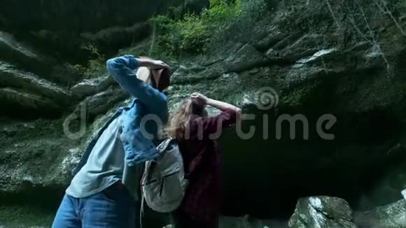两位年轻的高加索女性旅行者沿着一个热带洞穴旅行背上行军背包灵感来自于视频的预览图