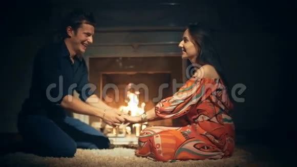 冬天晚上情侣们在浪漫的壁炉边喝杯酒放松视频的预览图