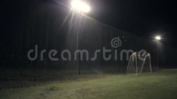 绿色足球场一排明亮的聚光灯照亮了夜晚的体育场视频的预览图