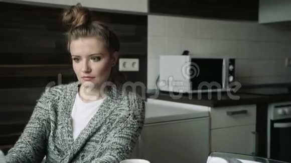 专注的女人在家里厨房里用笔记本电脑喝酒视频的预览图