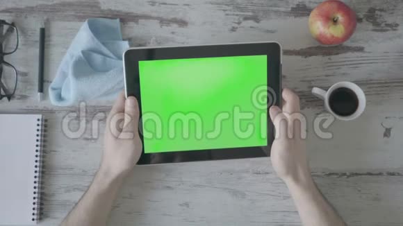 手拿平板电脑与绿色空屏幕木制背景视频的预览图