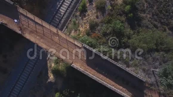 桥上和铁路上山地自行车骑行者的俯视图视频的预览图