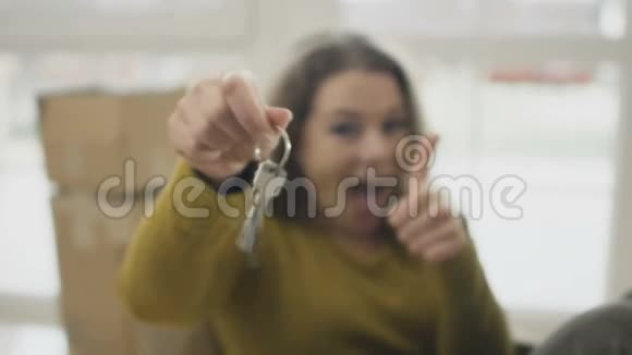 带着新房子钥匙在特写镜头中微笑的女人视频的预览图