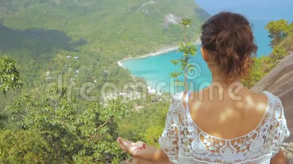 女孩在瑜伽姿势与风景如画的岛屿在高度视频的预览图