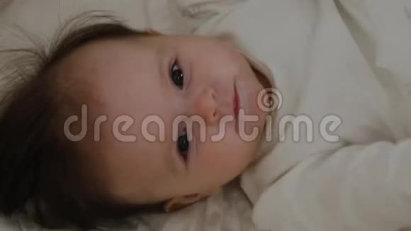 美丽的小女孩醒来对着镜头微笑视频的预览图