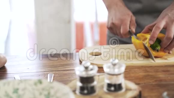 一名厨师在木板上切一根黄色的胡椒粉视频的预览图
