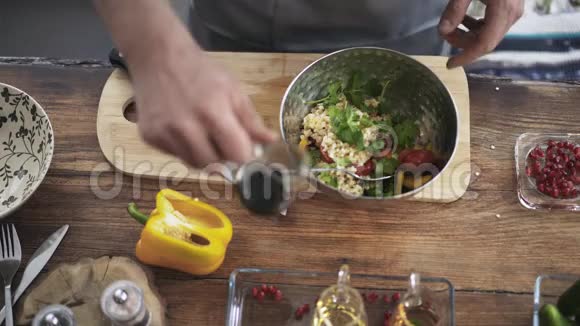 在蔬菜沙拉中加入酱汁和橄榄油的厨师的俯视图视频的预览图