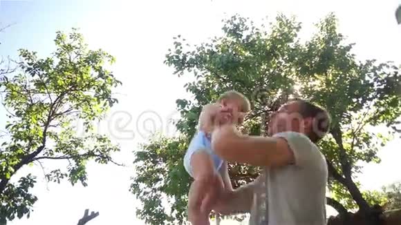 快乐的中年男人抱着他的小宝宝年轻的父亲和他的女儿玩耍视频的预览图