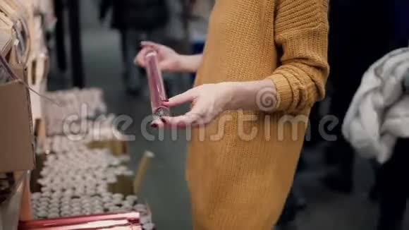 穿橙色毛衣的年轻女子选择包装纸圣诞装饰视频的预览图