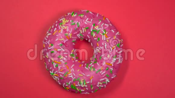 美味的粉红色甜面圈在盘子上旋转上景视频的预览图