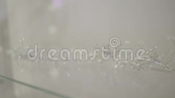 漂亮的白色头饰令人难以置信的珍珠头发配件透明玻璃桌背景特写镜头视频的预览图
